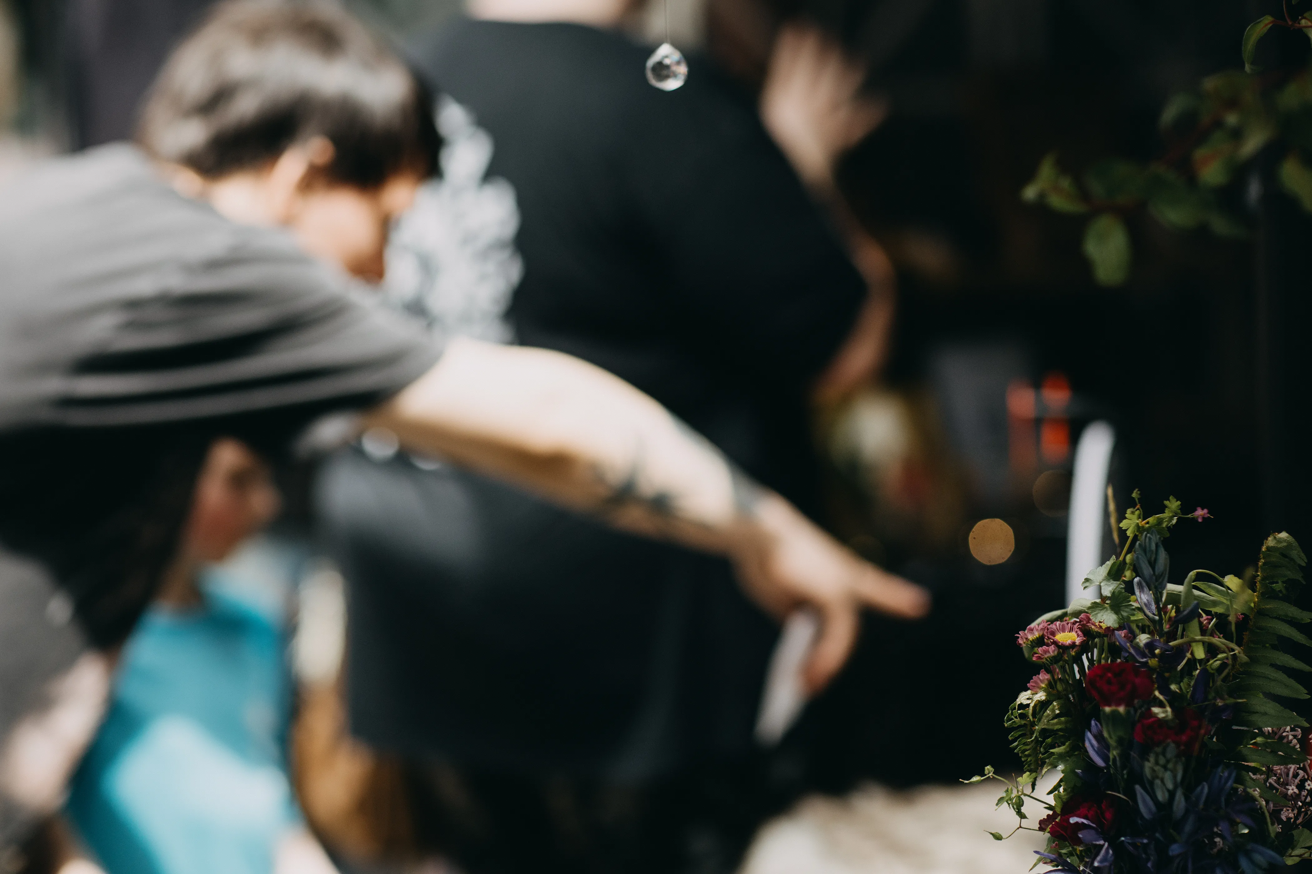A dehydrated flower arrangement with a customer reaching for an item in the background.
