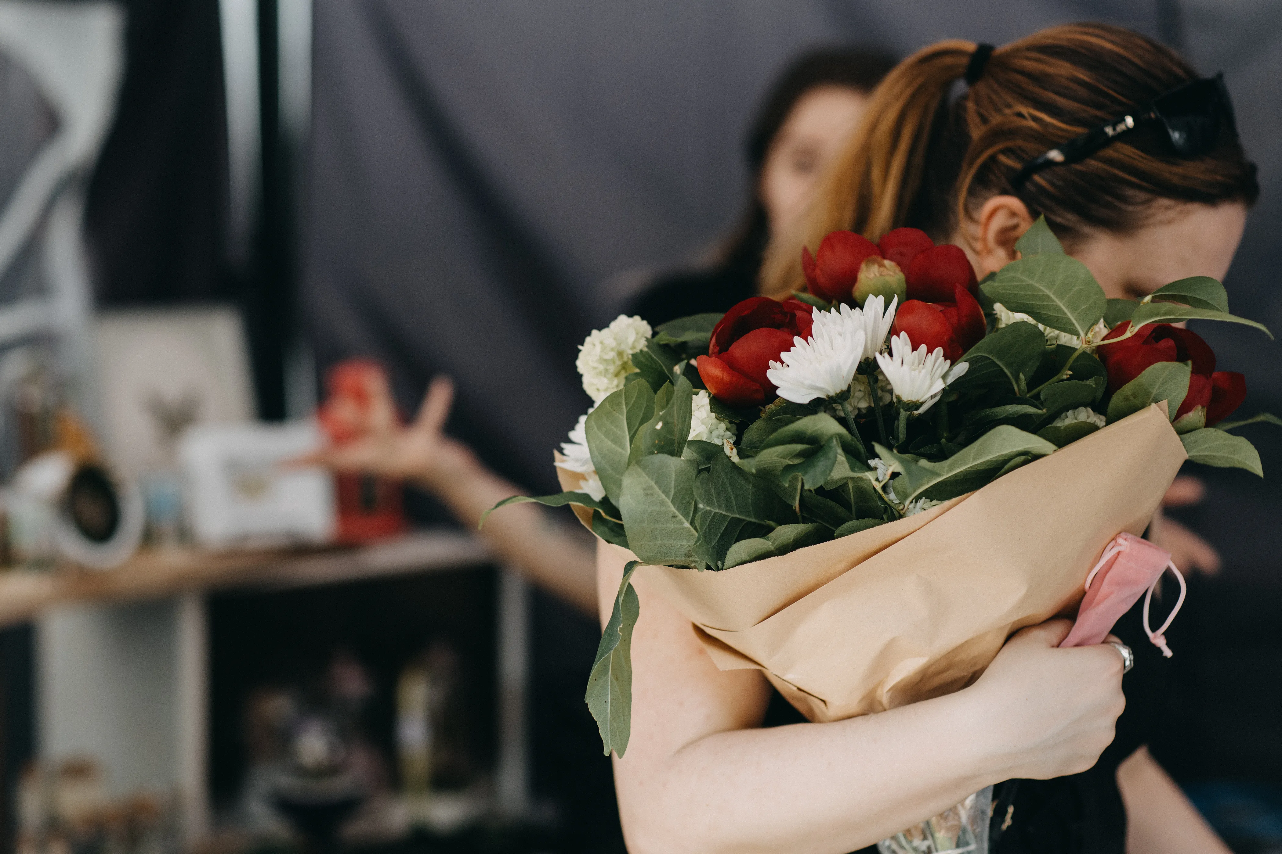 A customer holding a bouquet of custom arranged flowers.