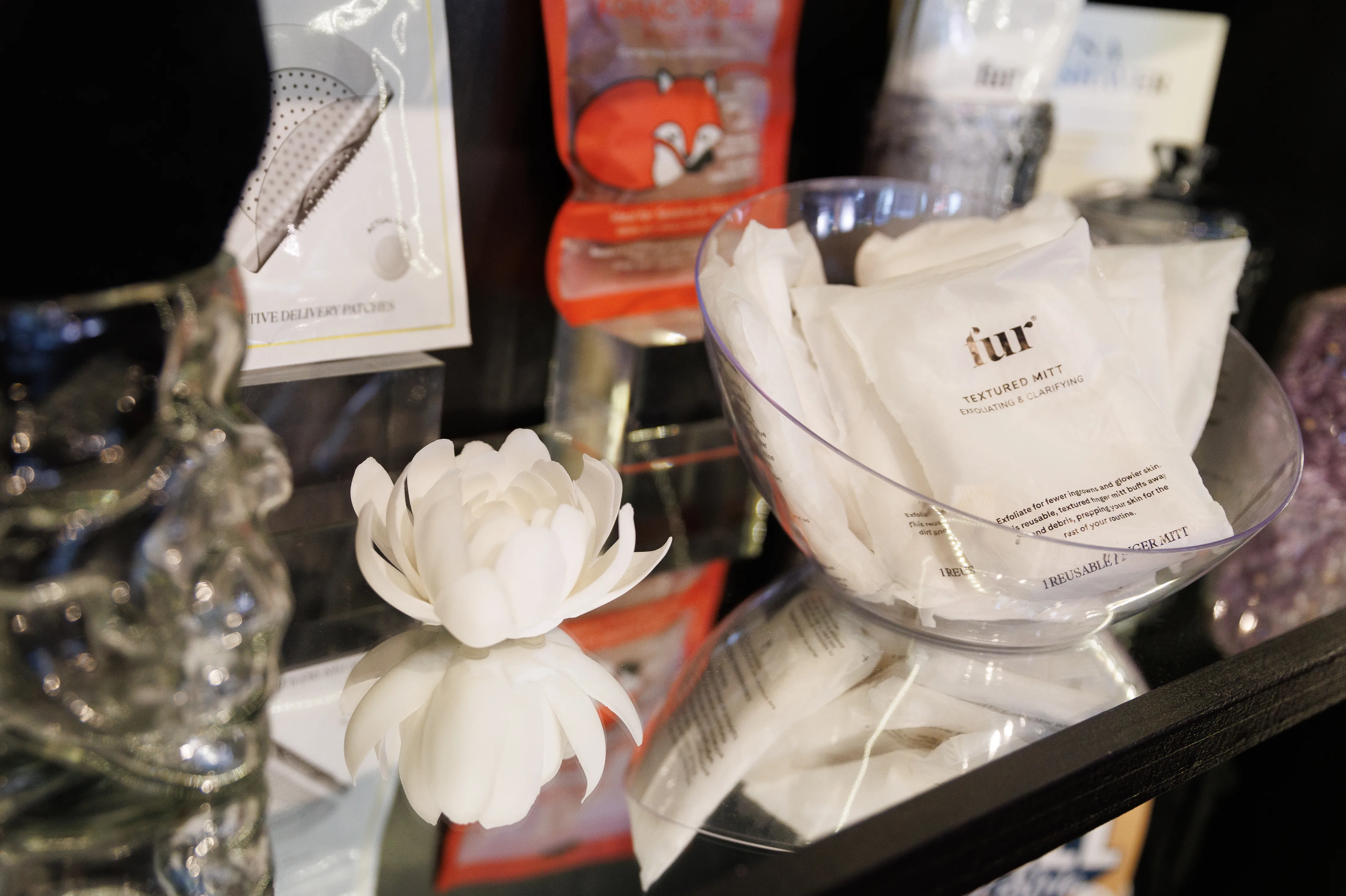A white flower on next to a display of exfoliating mitts