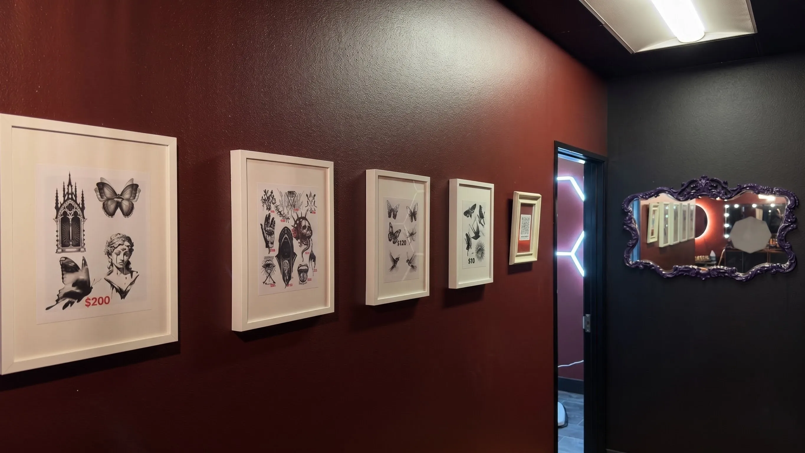 A gallery of framed fine line tattoo designs available at the club